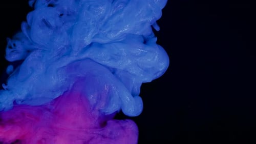 Blaue und rote Tinte vermischen sich auf einem abstrakten Hintergrund.