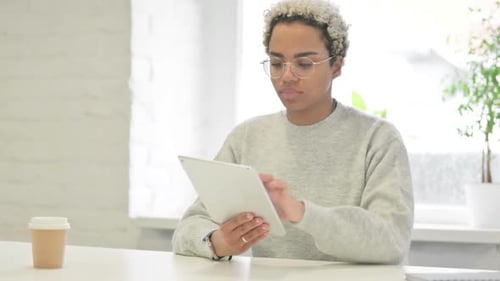 African Woman Using Tablet While Sitting in Office