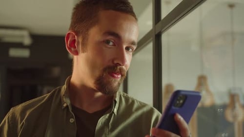 Bearded Man Using Smartphone Looking at Camera