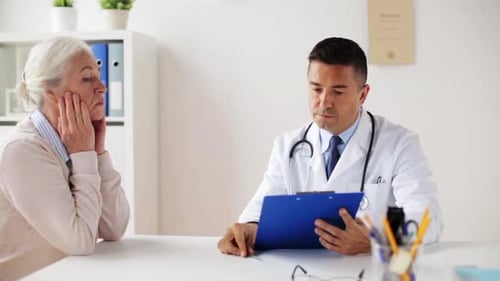 Senior Woman and Doctor Meeting at Hospital