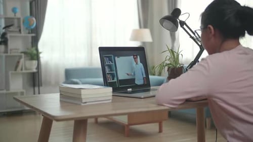 Child Watches Teacher on Laptop During Video Call