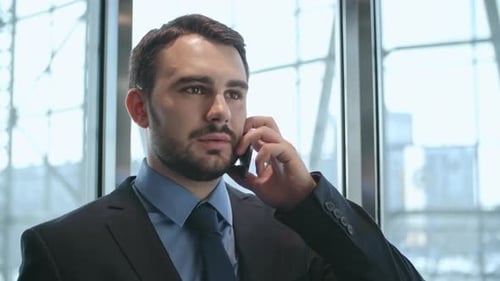 Serious businessman talking on smartphone