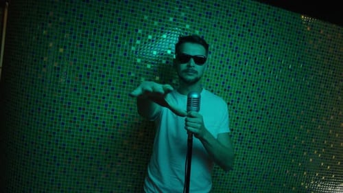 Mature Guy Put on Modern Sunglasses and White Tshirt Dances Holding Microphone
