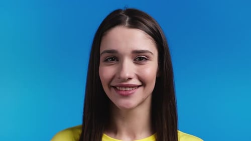Smiling Woman Close-up Portrait on Blue Background
