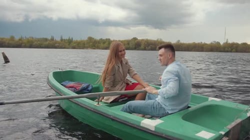 A Man and His Smiling Sweetheart During a Romantic Boat Ride on the River