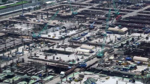 Large construction site with heavy construction machinery in metropolis