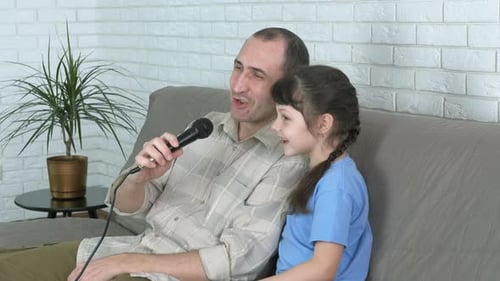 Father and Daughter Singing Karaoke at Home