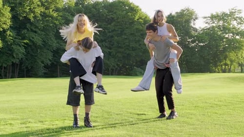 Group of Teenagers 16 17 Years Old are Having Fun Together in Summer in Park on Green Lawn