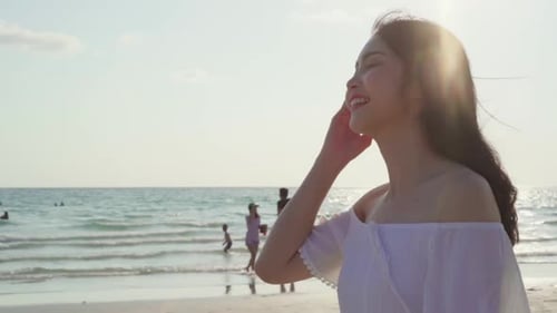 Beautiful female happy relax walking on beach near sea when sunset in evening.