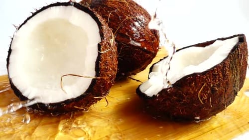 Water Pours Over Delicious Coconuts on Cutting Board