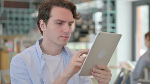 Portrait of Young Man Reacting to Loss on Tablet