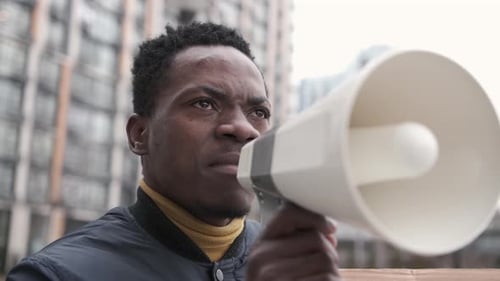 Man Speaking into Megaphone in Urban Environment