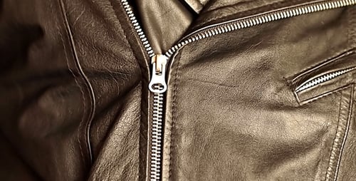 Hand Zipping Up a Leather Jacket Close Up