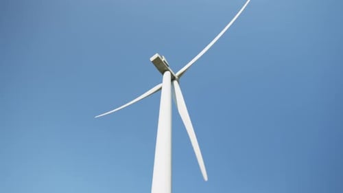 Wind Turbine Spinning Against Blue Sky