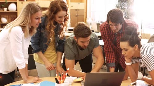 Young Professionals Collaborating Around a Table With Laptop