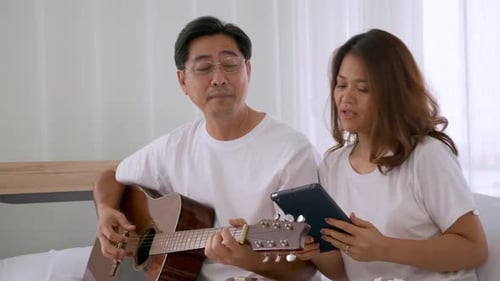 Couple Sings and Plays Guitar Together at Home