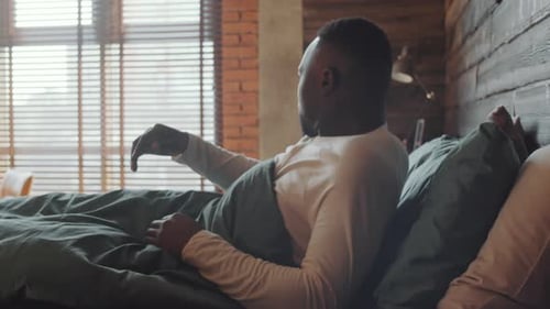 Man Wakes Up, Stretches, Checks Phone in Bed