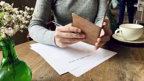 Woman Completes Visa Application Referencing Passport Over Coffee