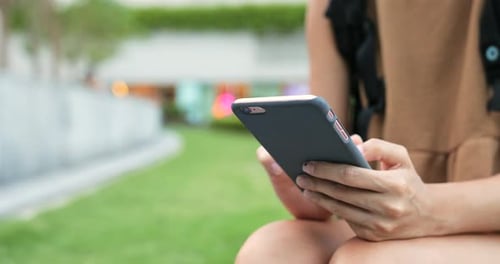 Frau benutzt Smartphone im Stadtpark