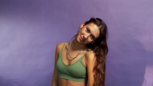 Young Girl with Brunette Hair is Dancing on a Purple Background