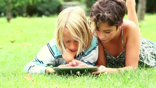 Children Play on Tablet in the Park