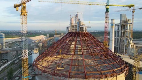 Aerial View of Cement Factory Under Construction with High Concrete Plant Structure and Tower Cranes