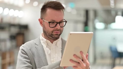Man Uses Tablet in Modern Office Setting