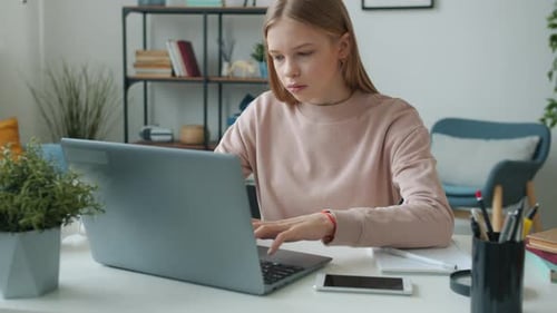 Tired Teenage Girl Working on Laptop at Home