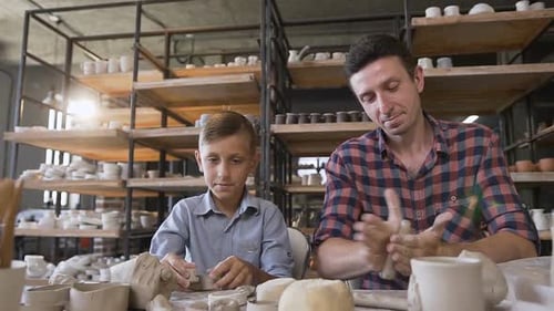Man and Child Creating Pottery in Bright Studio
