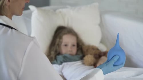 Scared Child Looking at Squeeze Bulb in Doctors Hand With Fear in Eyes, Medicine