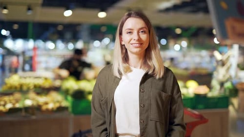 young woman chooses and picks in eco bag vegetables or fruits Oranges in the supermarket.