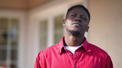 Young Worried African American Man Thinking Looking Away Standing on Porch on Backyard