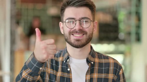 Young Adult Giving a Thumbs Up Gesture