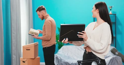 Couple Unpacking Belongings in New Home