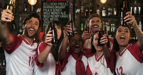 Friends cheering while having beer at bar counter