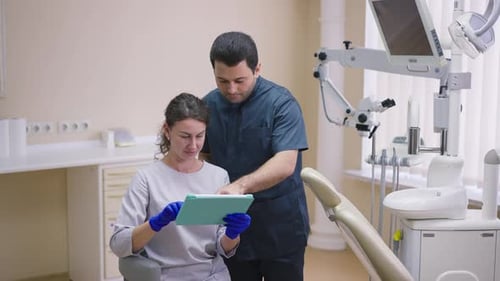 Middle Eastern Man and Caucasian Woman Thinking Planning Treatment in Dentist Office Indoors