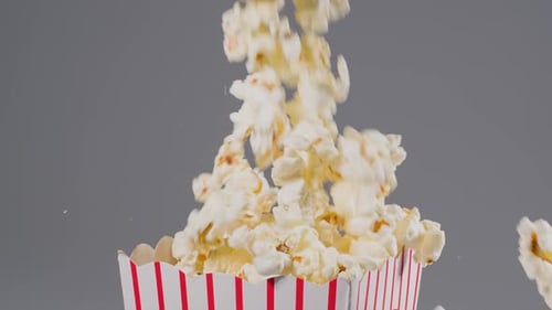 Popcorn falling in slow motion into a popcorn bucket