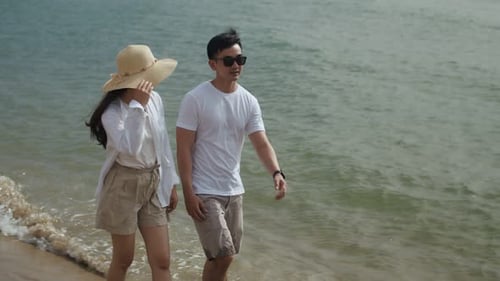 Couple Walking on Beach Together on Sunny Day