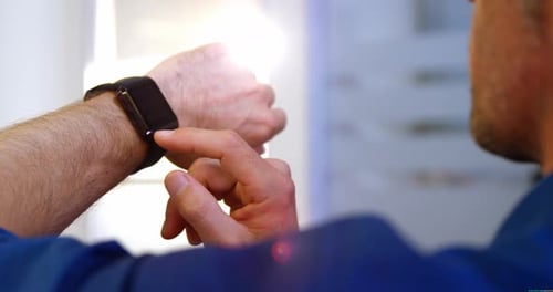 Close-up of male business executive using smart watch