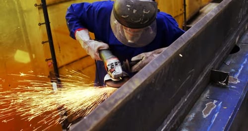 Male engineer using grinder machine
