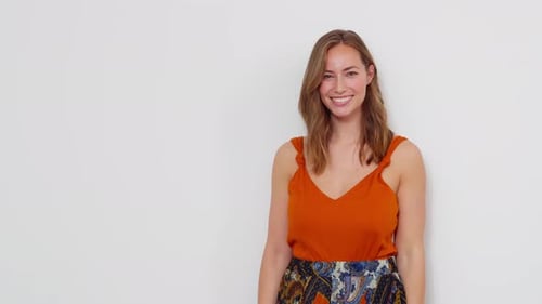 Woman Smiles in Front of a White Wall