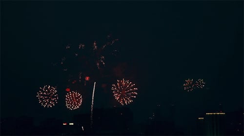 Fireworks Exploding Over City Skyline at Night
