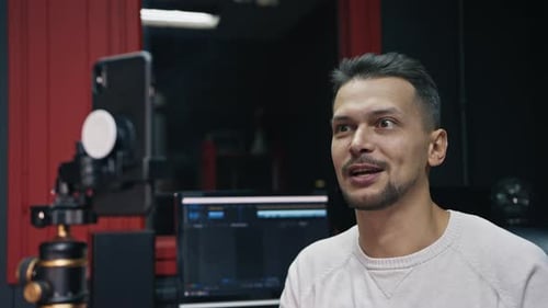 Man Talking to Camera Phone in Office