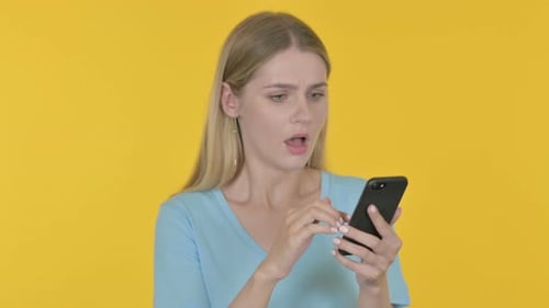 Woman Reacts to Phone News with Frustration