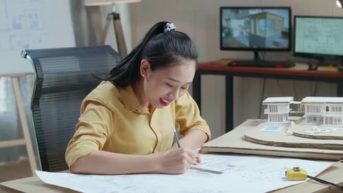 Ingeniero mujer asiática con un portátil dibujo plano en la oficina
