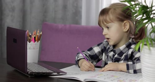 Young Child Drawing With Pencil in Workbook