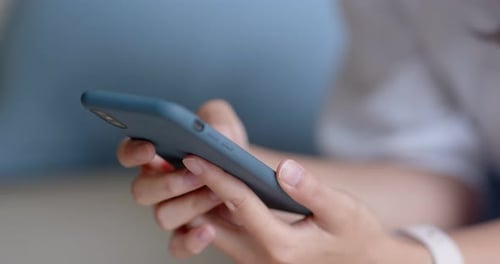 Close up Of Woman Use of Mobile Phone and Sit on Couch