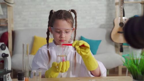 Young Girl Scientist Experiments with Red Liquid