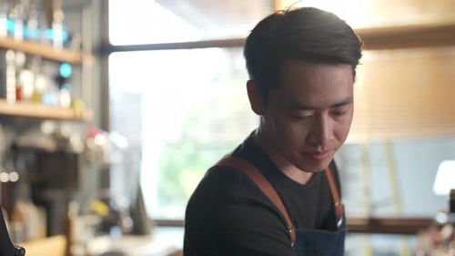 4K Asian man coffee shop waitress using alcohol sanitizer cleaning counter bar