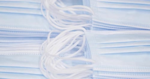 Pile Of Disposable Medical Face Masks - close up, tilt down